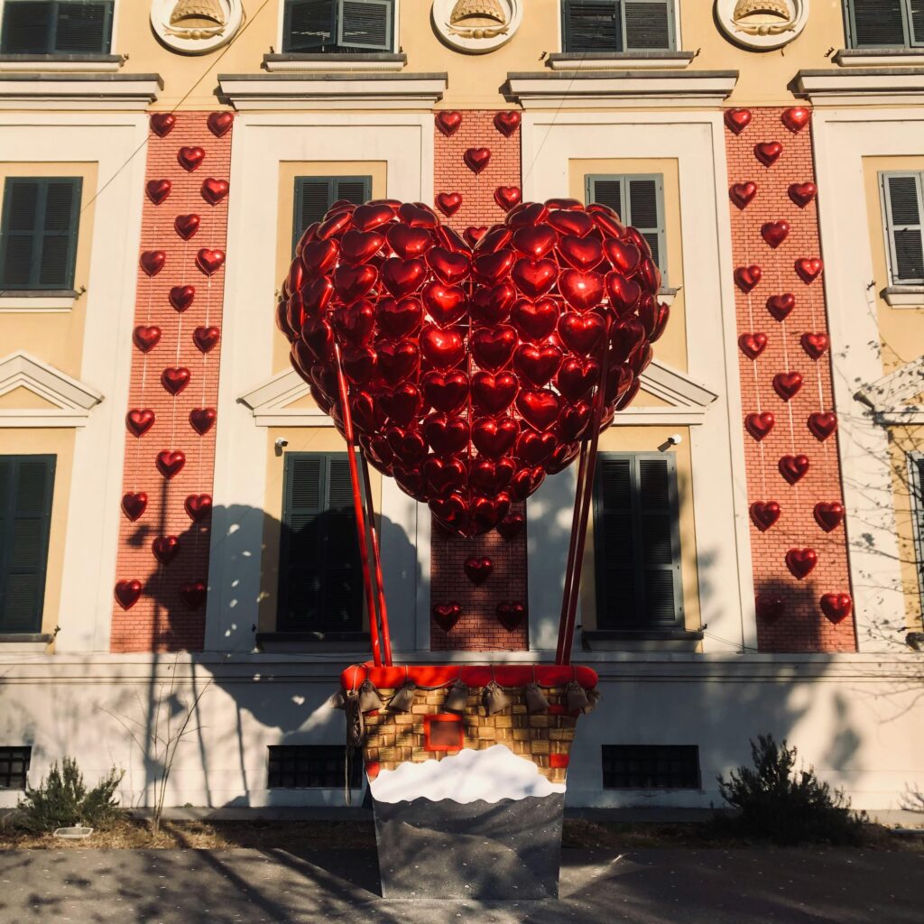 A heart-shaped balloon installation in front of a building facade in Tirana, Albania.